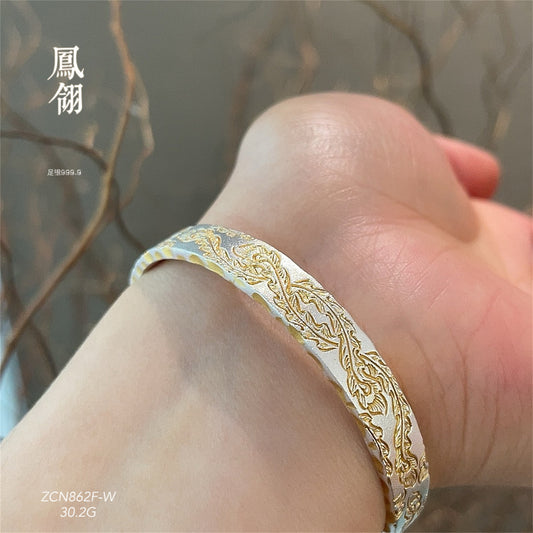 Pulsera de plata martillada con pluma de fénix pintada en oro