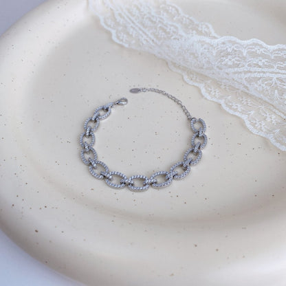 Pulsera hueca de plata de ley con microincrustaciones de circonitas y diamantes.