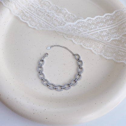 Pulsera hueca de plata de ley con microincrustaciones de circonitas y diamantes.